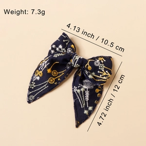 Navy blue embroidered bow hair clip with floral patterns and measurement annotations