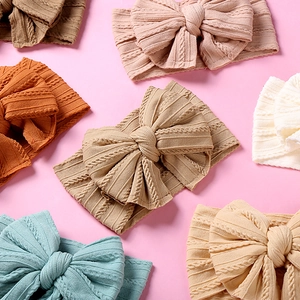 Gros plan de bandeaux bébé en nylon doux avec doubles nœuds en diverses couleurs