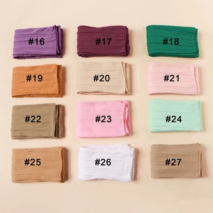 Detailed view of twelve colorful cable knit nylon headbands for infants and newborns