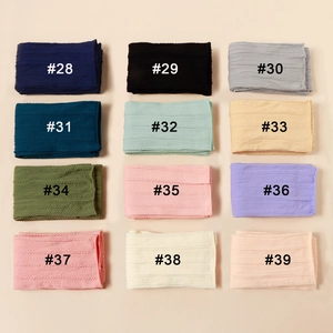 Close-up of 12 multi-color baby nylon jacquard headbands with cable knit texture