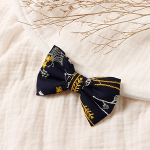 Détails de broderie florale sur nœud de cheveux bleu marine en coton et lin vintage