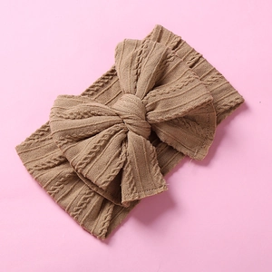 Détails de la maille torsadée du bandeau marron pour bébé avec un grand nœud décoratif