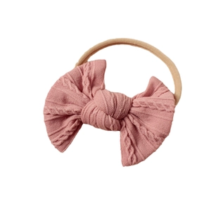 Rosa Baby Stirnband mit Strickschleife und weichem elastischem Band auf weißem Grund