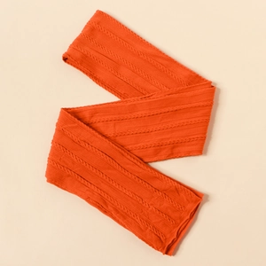 Macro detail of bright orange cable knit fabric texture for newborn baby headbands