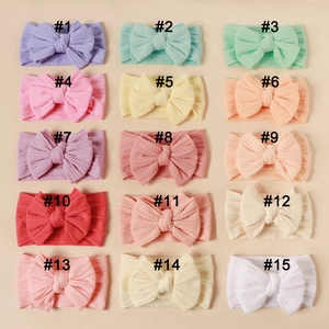 Detailed grid of 15 colorful elastic baby headbands with large double layer knit bows