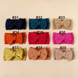 Close-up of baby nylon headbands with double-layer bows in nine diverse colors