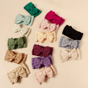 Macro detail of multi-color cable knit baby bow headbands in various soft textures