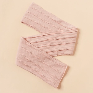 Detailed macro shot of pale pink cable knit fabric texture and elastic weave pattern