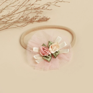 Vue détaillée du bandeau bébé avec fleurs en dentelle fait main et élastique doux