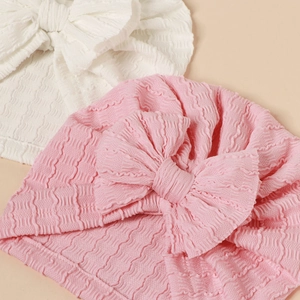Elastic baby turban hats with large bows in pink and white waffle texture fabric