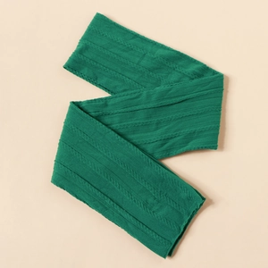 Detail of dark green nylon jacquard baby headband with soft cable knit texture