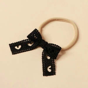 Dettaglio dell'archetto in pizzo nero con eleganti motivi a cuore traforati