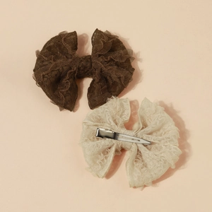 Détail des pinces à cheveux en dentelle avec nœuds papillon et attaches en métal chic