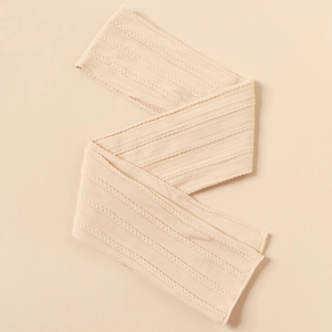 Close-up of beige nylon jacquard baby headband with soft knitted cable texture