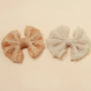 Vue détaillée des pinces à cheveux en dentelle avec texture en maille et plis élégants