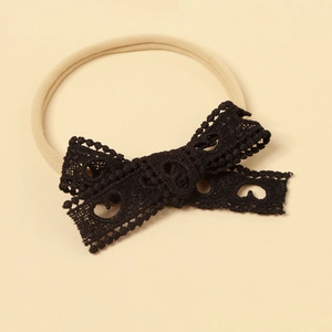 Detail of baby lace bow headband with hollow heart patterns on high elastic nylon band