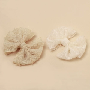Détail macro du tissu en dentelle souple sur des barrettes nœuds papillon à double couche