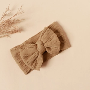 Macro shot of khaki knit nylon baby headband with large double bow texture detail