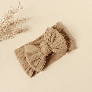 Detail of baby nylon headband featuring a large double-layer jacquard knit bow in khaki