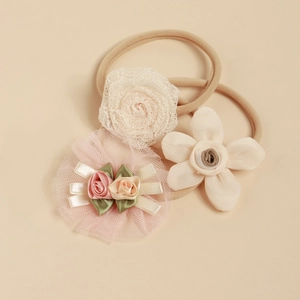Détail de 3 bandeaux bébé avec fleurs en dentelle rose et bandes en nylon souple