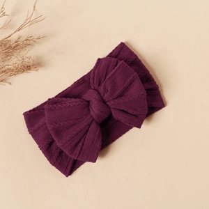 Detail showing the deep purple knitted rib texture and double-layered bow of the nylon headband