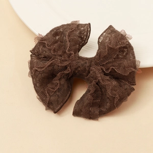 Gros plan sur l'élégante pince à cheveux en dentelle marron foncé avec n&oelig;ud multicouche