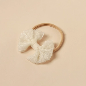 Detailaufnahme des Baby-Spitzenbogen-Stirnbands mit weichem Nylon und gewellter Spitze
