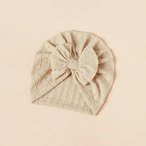 Detail of baby turban hat with ribbed knit texture and large soft bow decoration