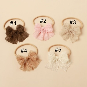 Detail of five vintage lace bow headbands for babies in assorted neutral colors