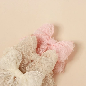 Elegant lace bow headbands for babies in pink and cream colors with delicate mesh layers