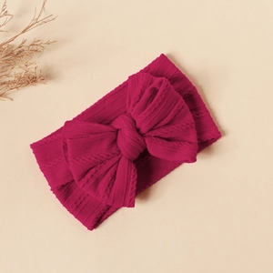 Detailed knit texture of dark pink infant nylon headband with double layer bow decoration
