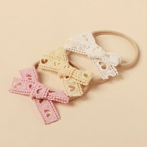 Set of three soft nylon baby headbands with lace hollow heart bows in pink and beige