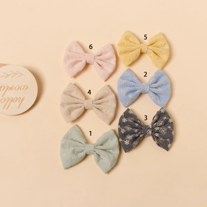 Détails de six barrettes noeuds brodés en coton aux couleurs douces et motifs floraux