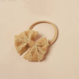 Detail eines Baby-Spitzenstirnbandes in Apricot mit elastischem Nylon und Netzstruktur