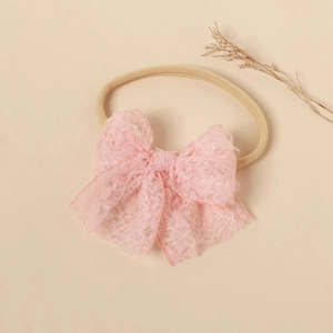 Close-up of pink lace bow on high-elastic nylon headband for infants and girls