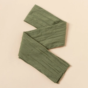 Close-up of green cable knit nylon fabric showing texture for DIY infant headbands