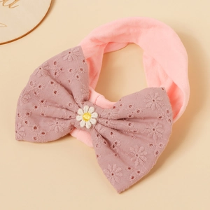 Close-up of pink nylon baby headband with embroidered bow and daisy detail