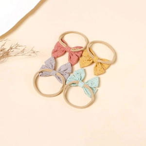 Set of four newborn nylon headbands with floral pointelle bows in pastel Morandi colors