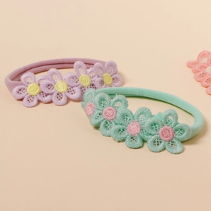 Detail of soft nylon baby headbands with delicate purple and mint lace flowers