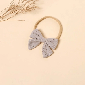 Close-up of baby nylon headband featuring a grey lace bow with floral embroidery details