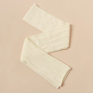 Detailed view of cream nylon cable knit jacquard baby headband with soft elastic texture