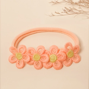 Detailed close-up of soft nylon baby headband with delicate peach flower embroidery