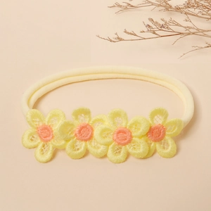 Detail view of yellow lace flowers on a soft nylon baby headband with embroidery