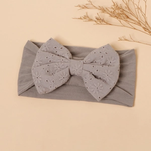 Detail of grey baby headband featuring a large floral embroidery bow and ribbed knit texture