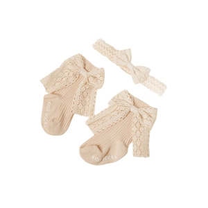 Nahaufnahme von Baby-Haarband und Spitzensocken Set in Creme mit Strickdetails