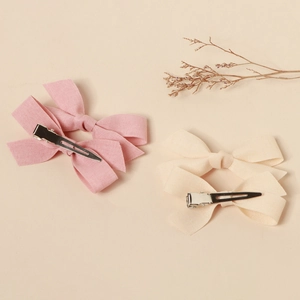 Detailed set of pink and beige fabric bow hair clips with silver alligator metal grips