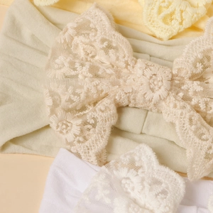Fascia per neonati elastica con grande fiocco in pizzo floreale nei colori bianco e beige
