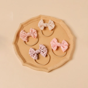 Set of four soft pink floral jacquard bow headbands with elastic nylon for infants