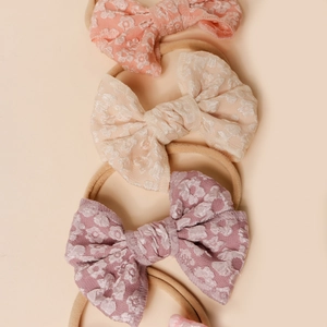 Elastic nylon baby headbands with floral lace bows in pink, cream, and mauve colors