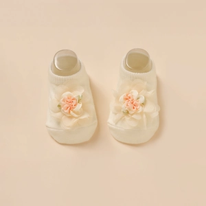 Détail de chaussettes bébé avec fleurs en tulle faites main sur maille couleur ivoire